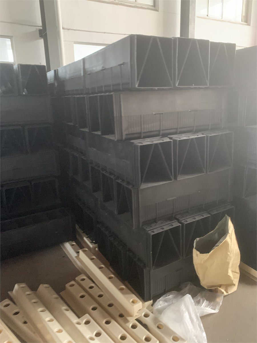 Filter bricks stacked in the workshop beside perforated media samples