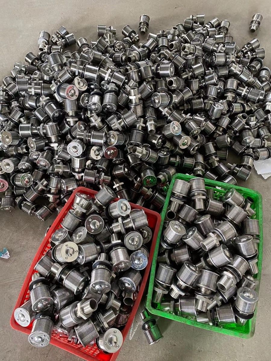 Stainless steel drain caps in bulk in parts baskets