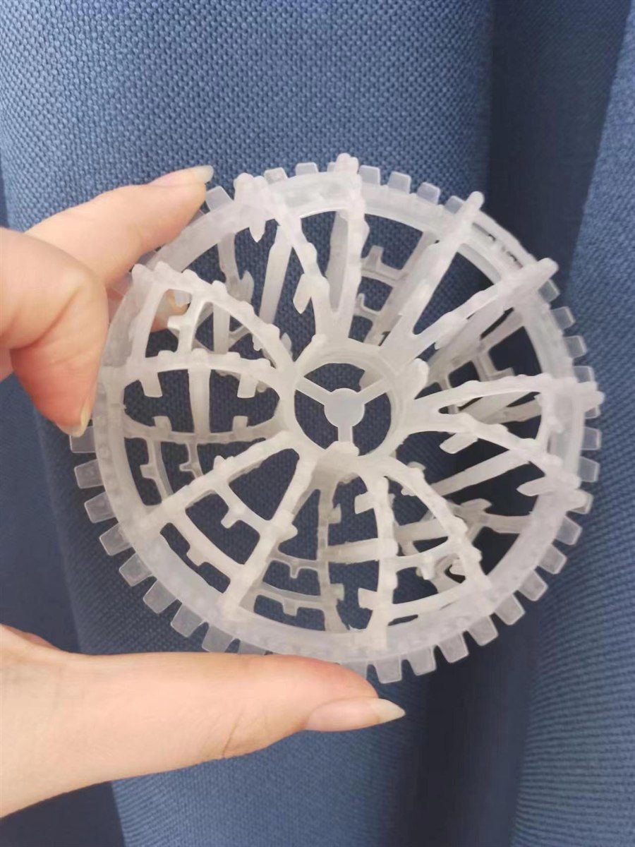 Hand holding one semi-transparent rosette ring against blue fabric